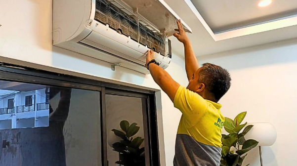 PrimeChem technician maintaining a wall-mounted AC unit